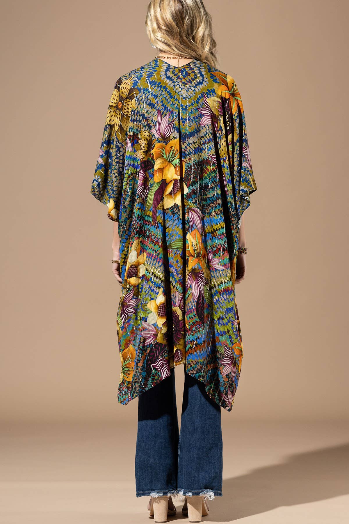 Person wearing a colorful floral kimono against a beige background
