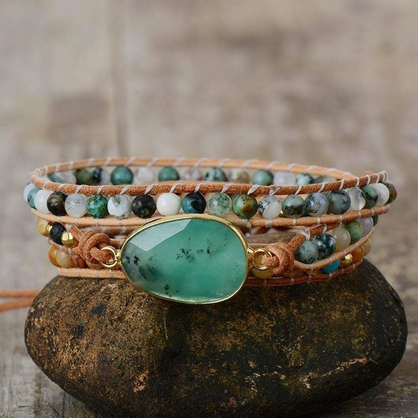 Multistrand bracelet with a green stone on a stone surface