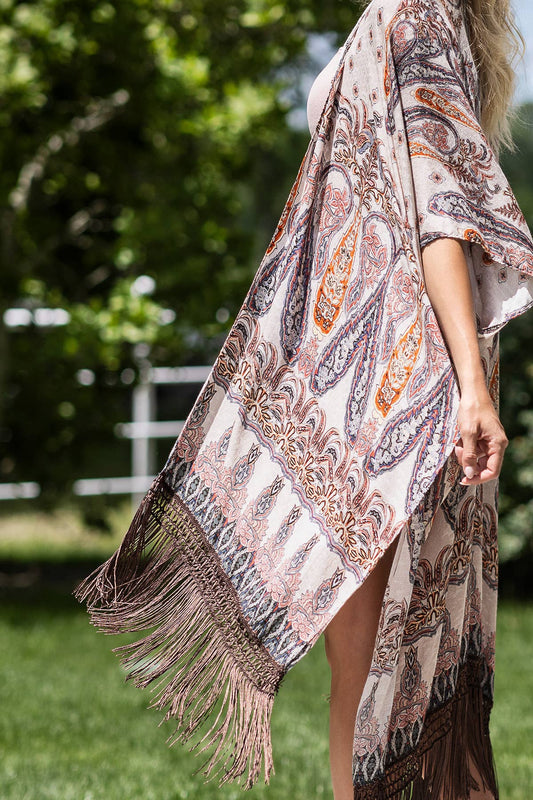 Woman wearing a patterned kimono with fringes outdoors