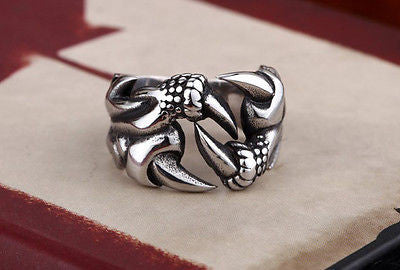 Silver ring with intricate design on a textured surface