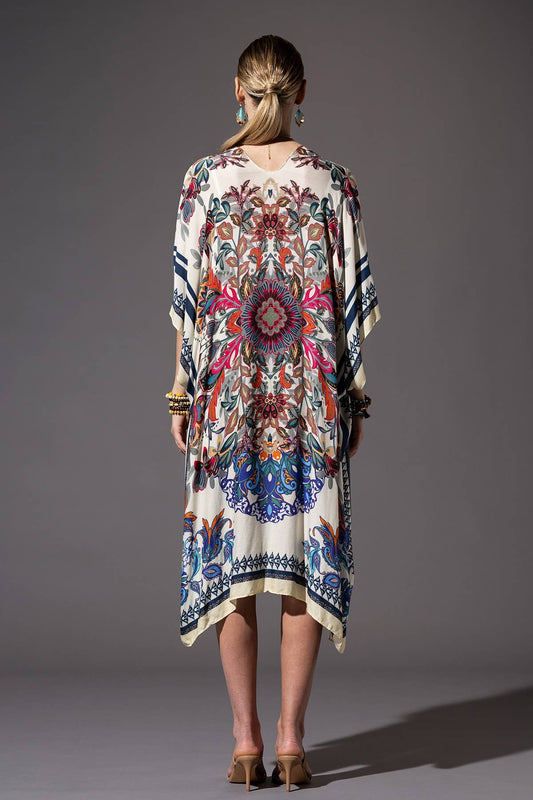 Woman wearing a colorful patterned dress against a gray background