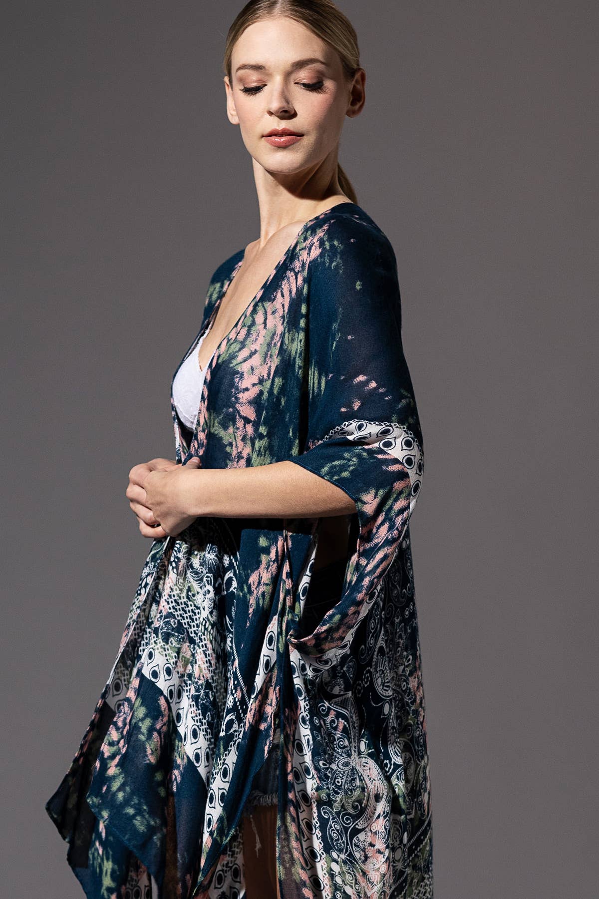 Woman wearing a patterned kimono-style garment against a gray background