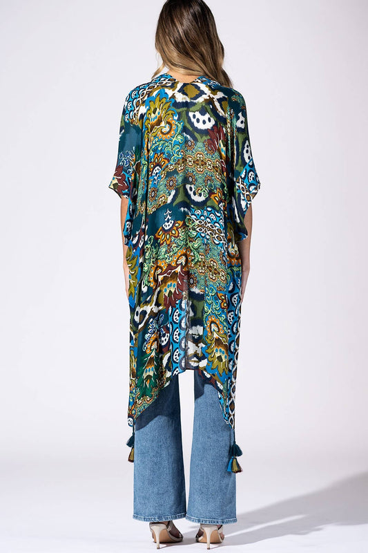 Woman wearing a colorful patterned kimono-style garment on a white background