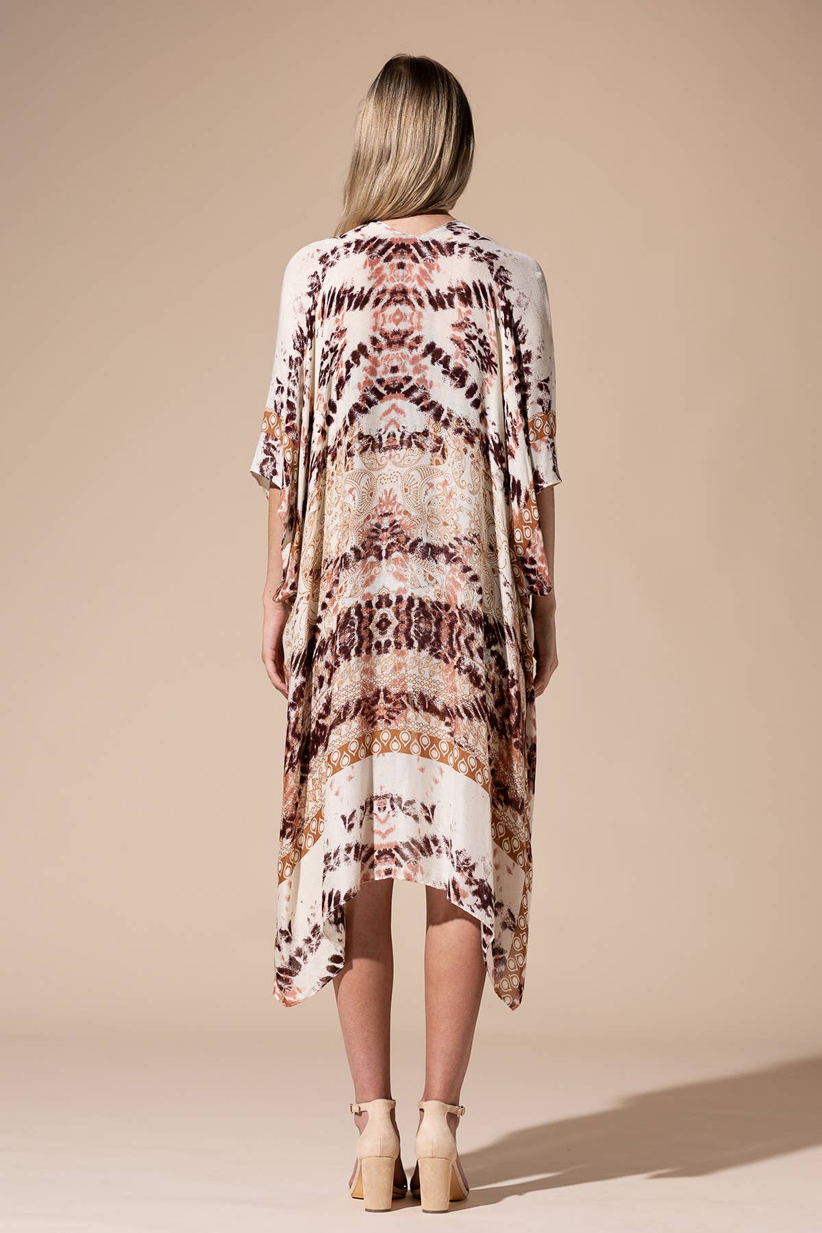 Woman wearing a patterned kimono-style garment against a beige background