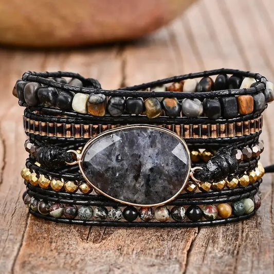 Multistrand beaded bracelet with a central stone on a wooden surface