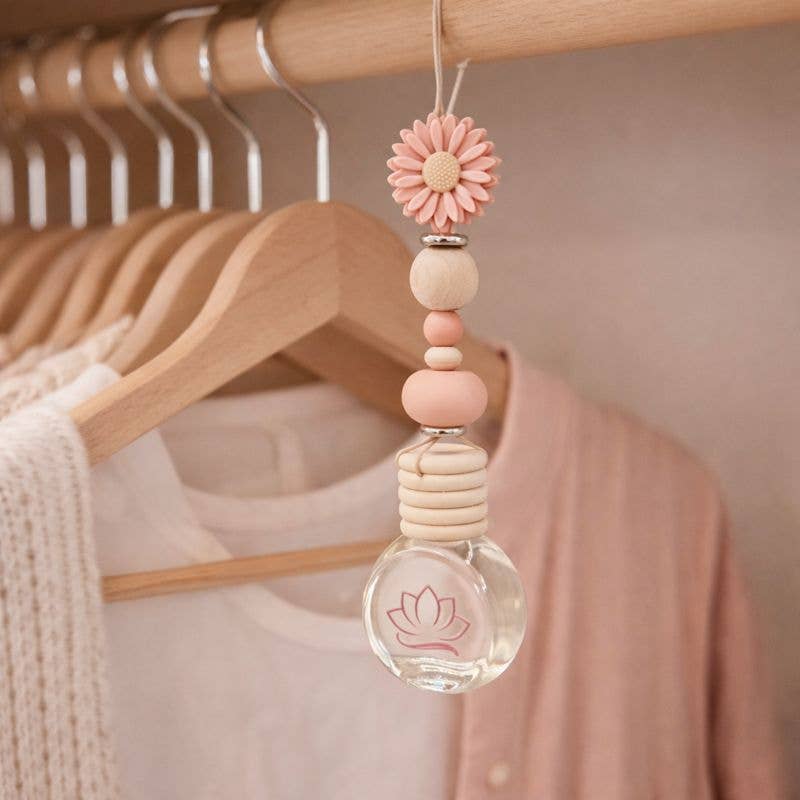 Decorative hanging pendant with pink flower and beads on a wooden hanger.
