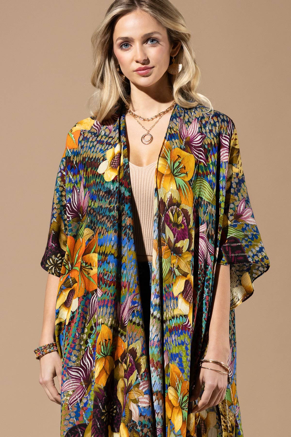 Woman wearing a colorful floral kimono against a beige background