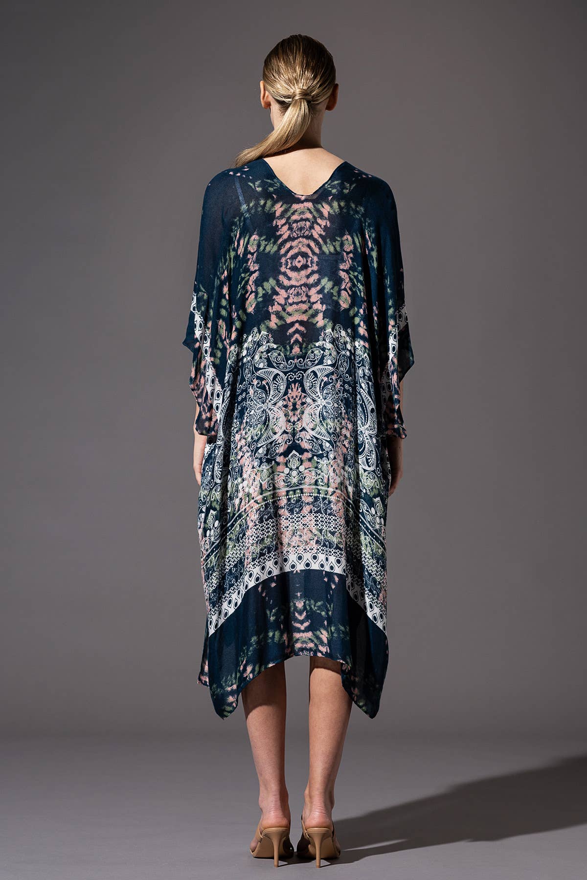Woman wearing a patterned dress with a plain background