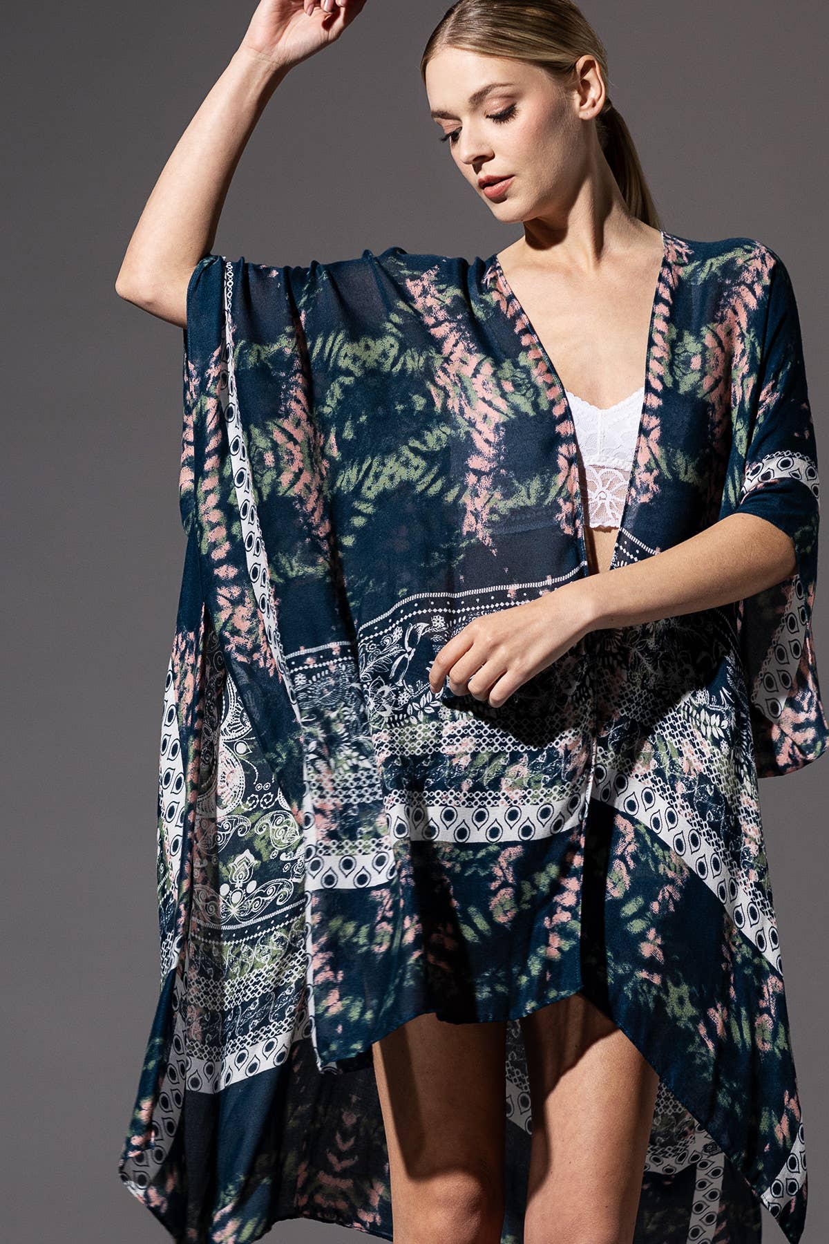Woman wearing a patterned kimono-style garment against a gray background