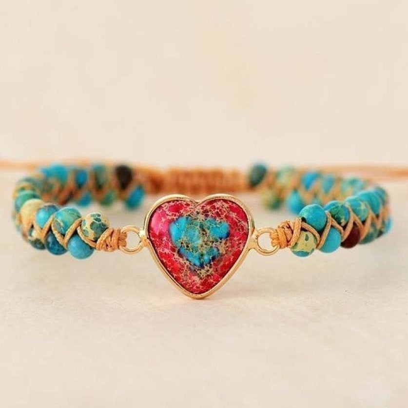 Bracelet with heart-shaped gemstone and multicolored beads on a beige background