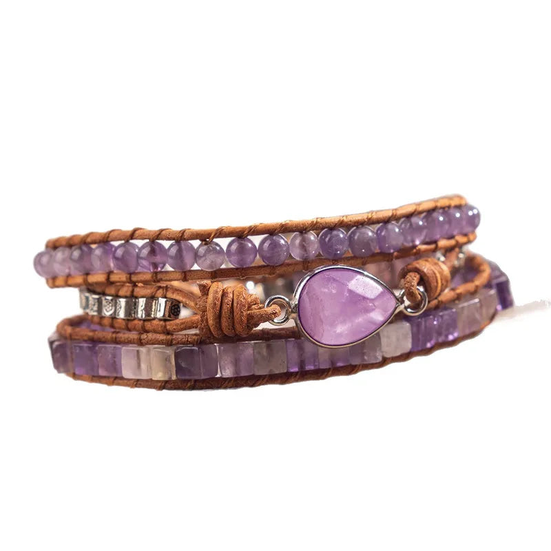 Purple beaded bracelet with a heart-shaped purple stone on a white background