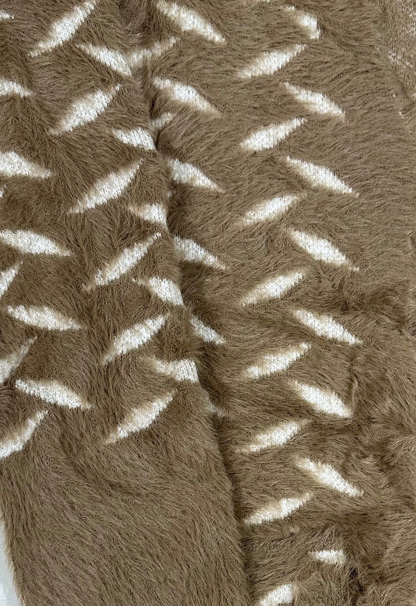 Close-up of a textured brown fabric with white patterns