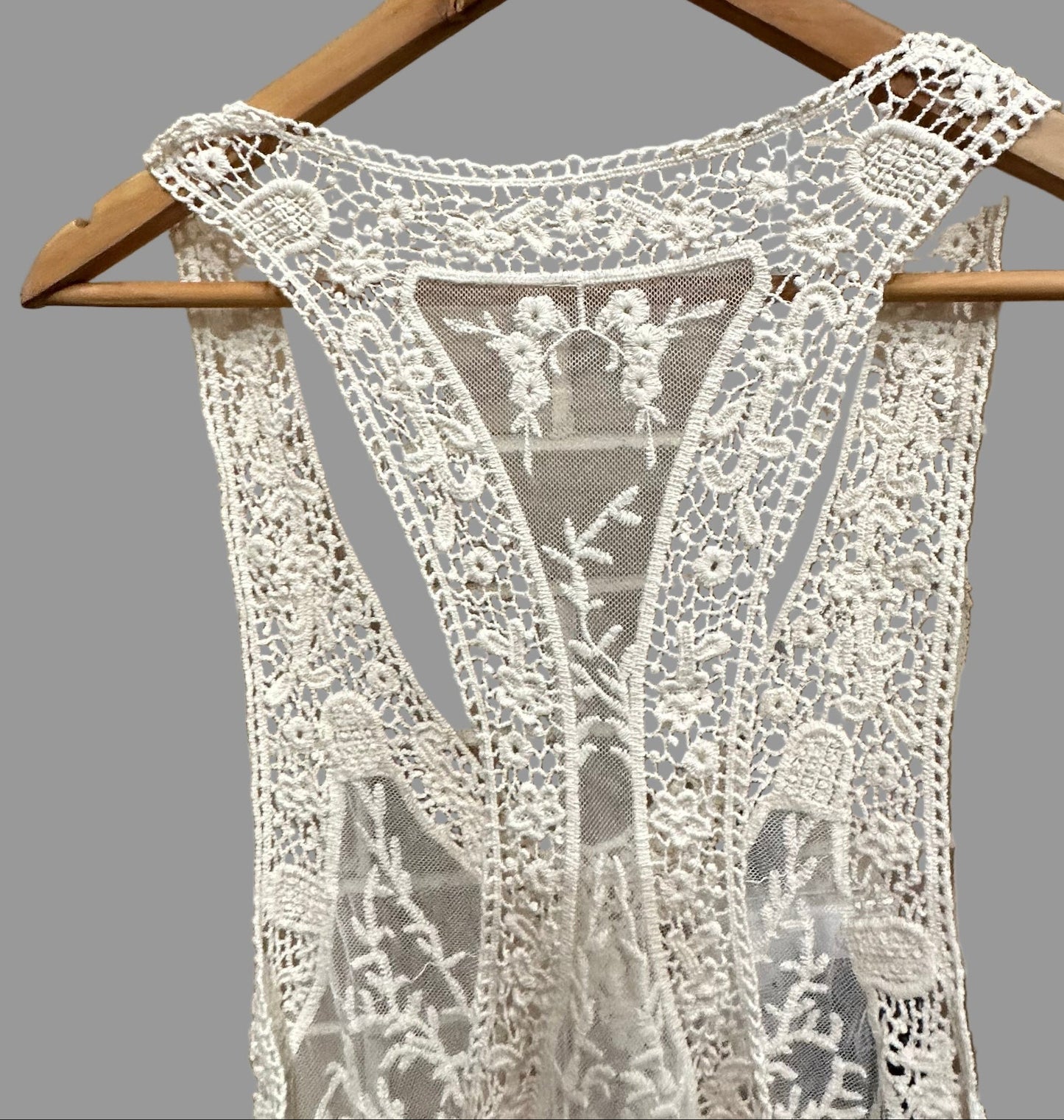 Lace dress on a hanger against a tiled wall