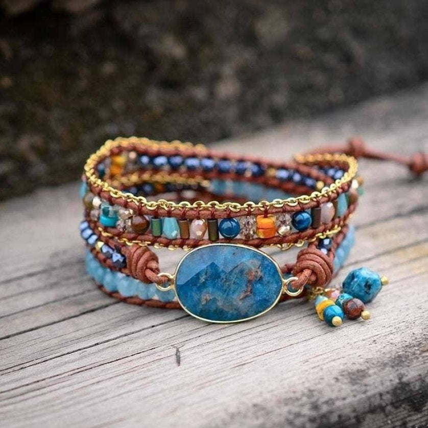 Multicolored beaded bracelet with a blue stone on a wooden surface.