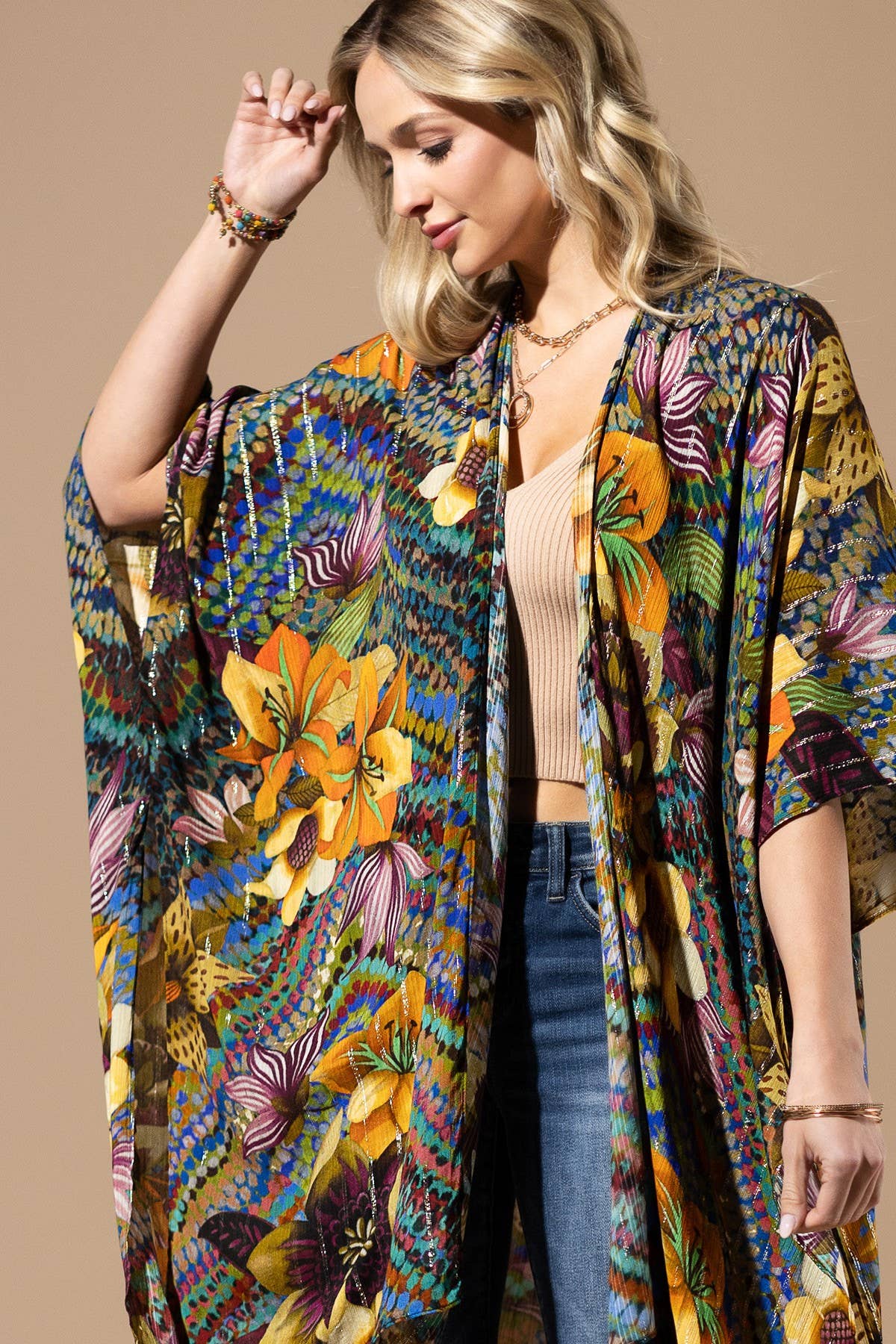 Woman wearing a colorful floral kimono against a beige background