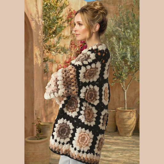 Woman wearing a floral-patterned crochet cardigan in an outdoor setting.