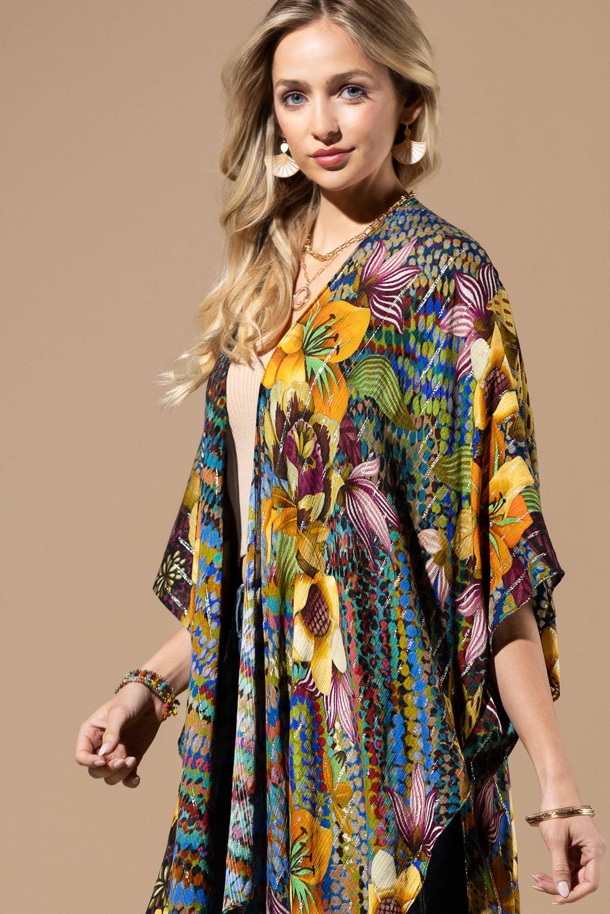 Woman wearing a colorful floral kimono against a beige background