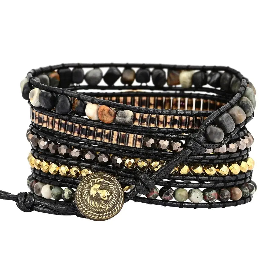 Multistrand beaded bracelet with black cord and decorative button on a white background