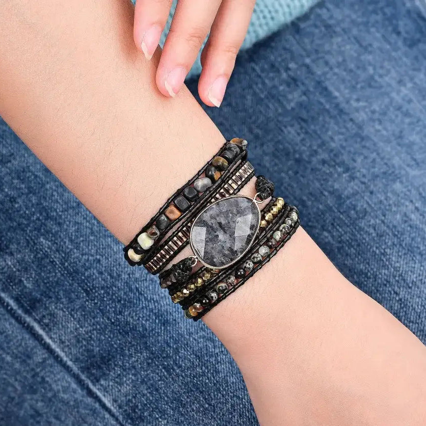 Stacked bracelets on a wrist with a denim background