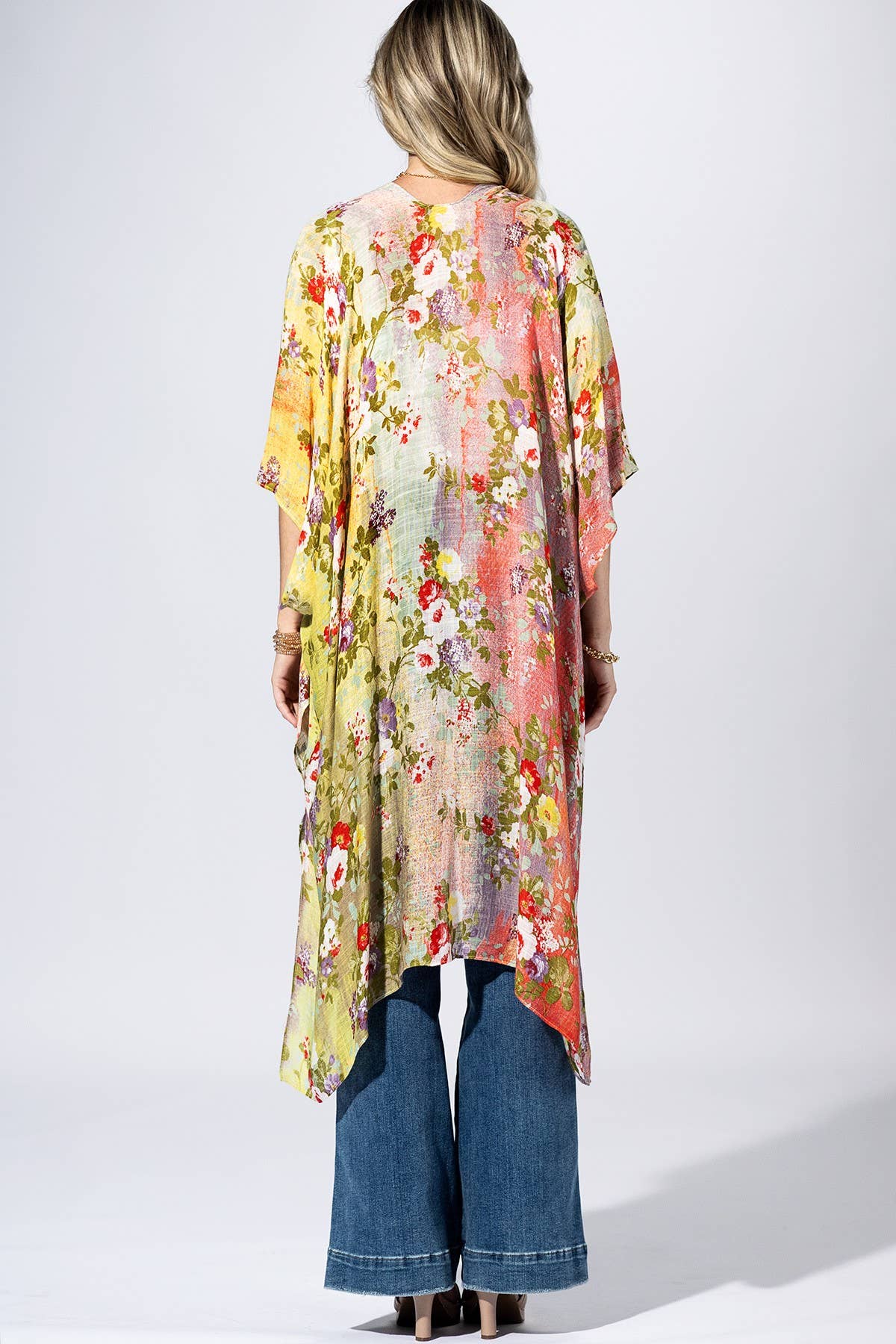 Woman wearing a colorful floral kimono-style garment on a white background