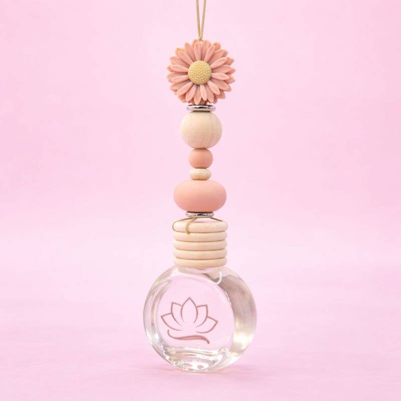 Decorative hanging car charm with pink beads and a clear glass bottom on a pink background