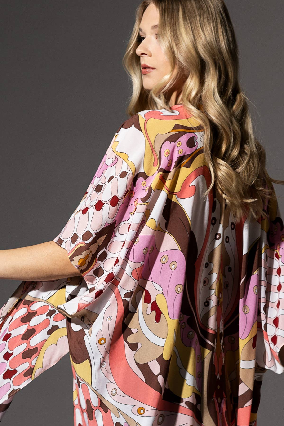 Woman wearing a patterned dress with a dark background