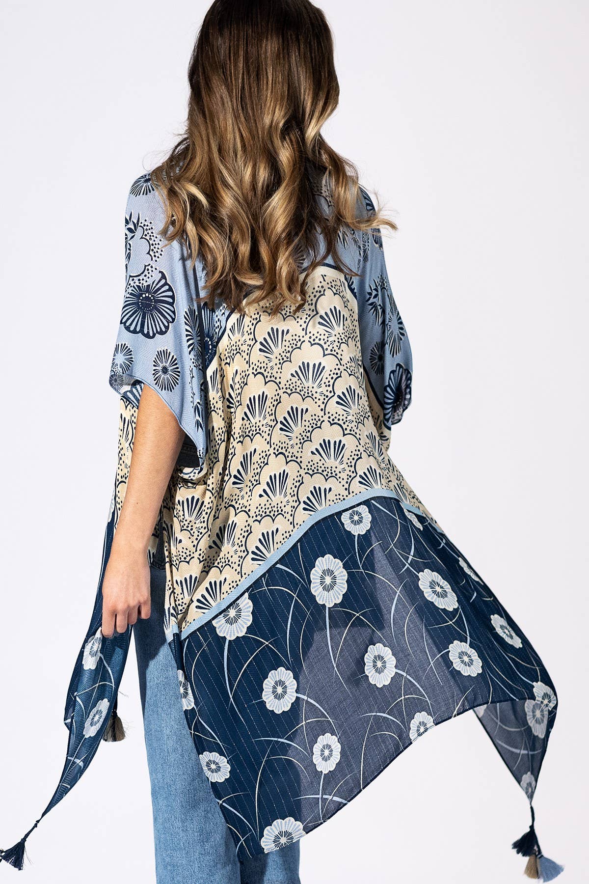 Woman wearing a floral kimono-style garment with a white background