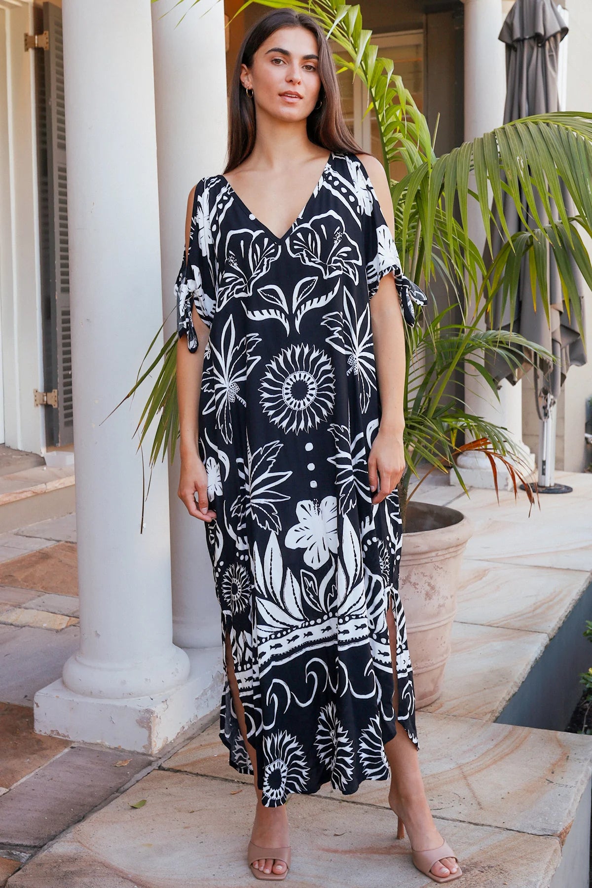Woman wearing a black and white patterned dress standing outdoors.