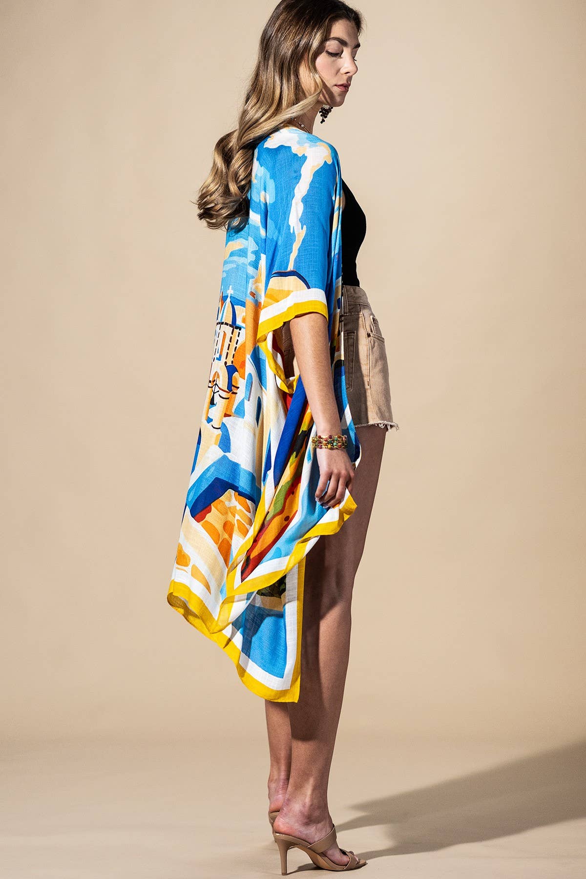 Woman wearing a colorful kimono-style garment against a beige background