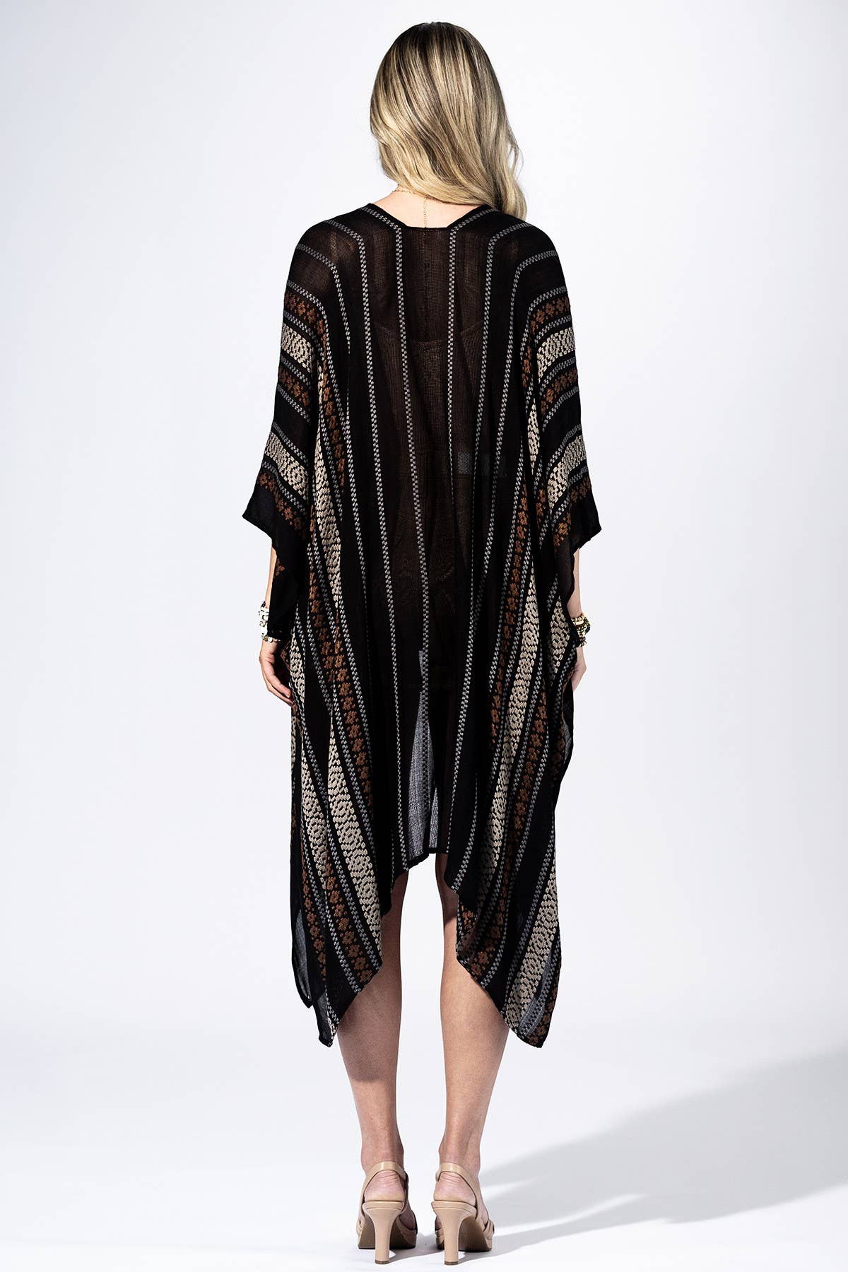 Woman wearing a black and brown patterned kimono-style garment on a white background
