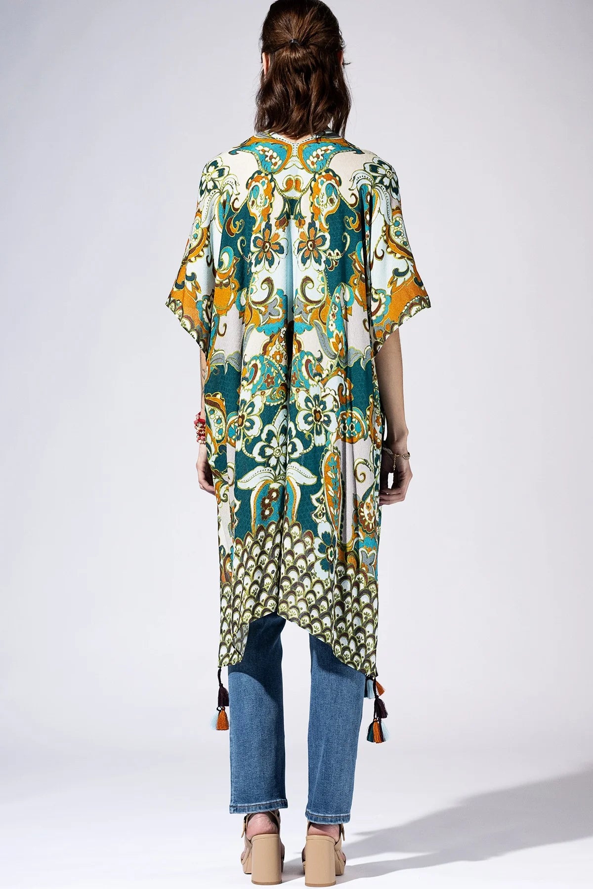 Person wearing a colorful patterned kimono over a plain background