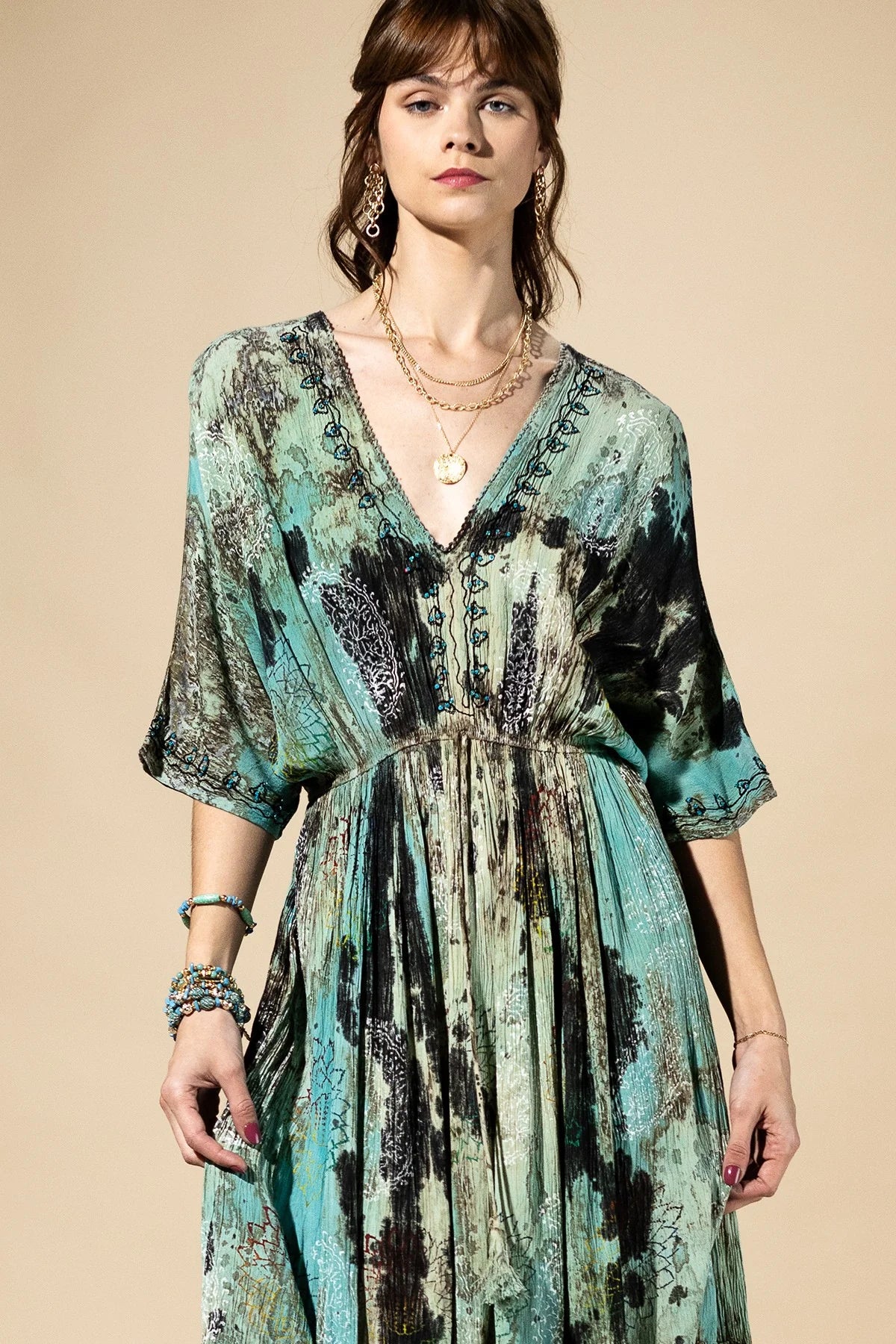 Woman wearing a patterned dress with a neutral background