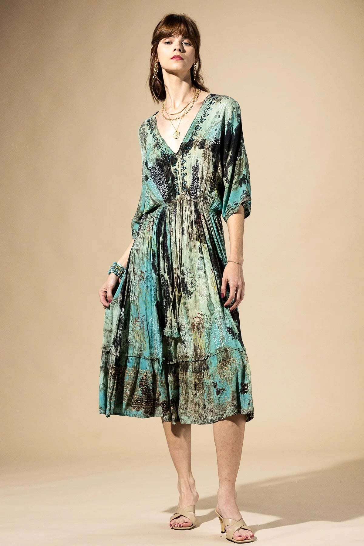 Woman wearing a patterned dress against a beige background