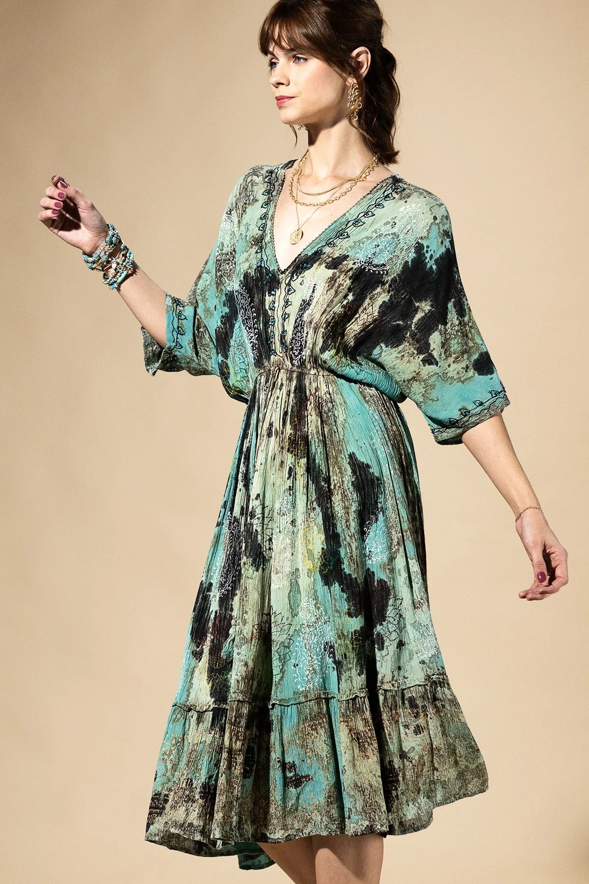 Woman wearing a patterned dress against a beige background