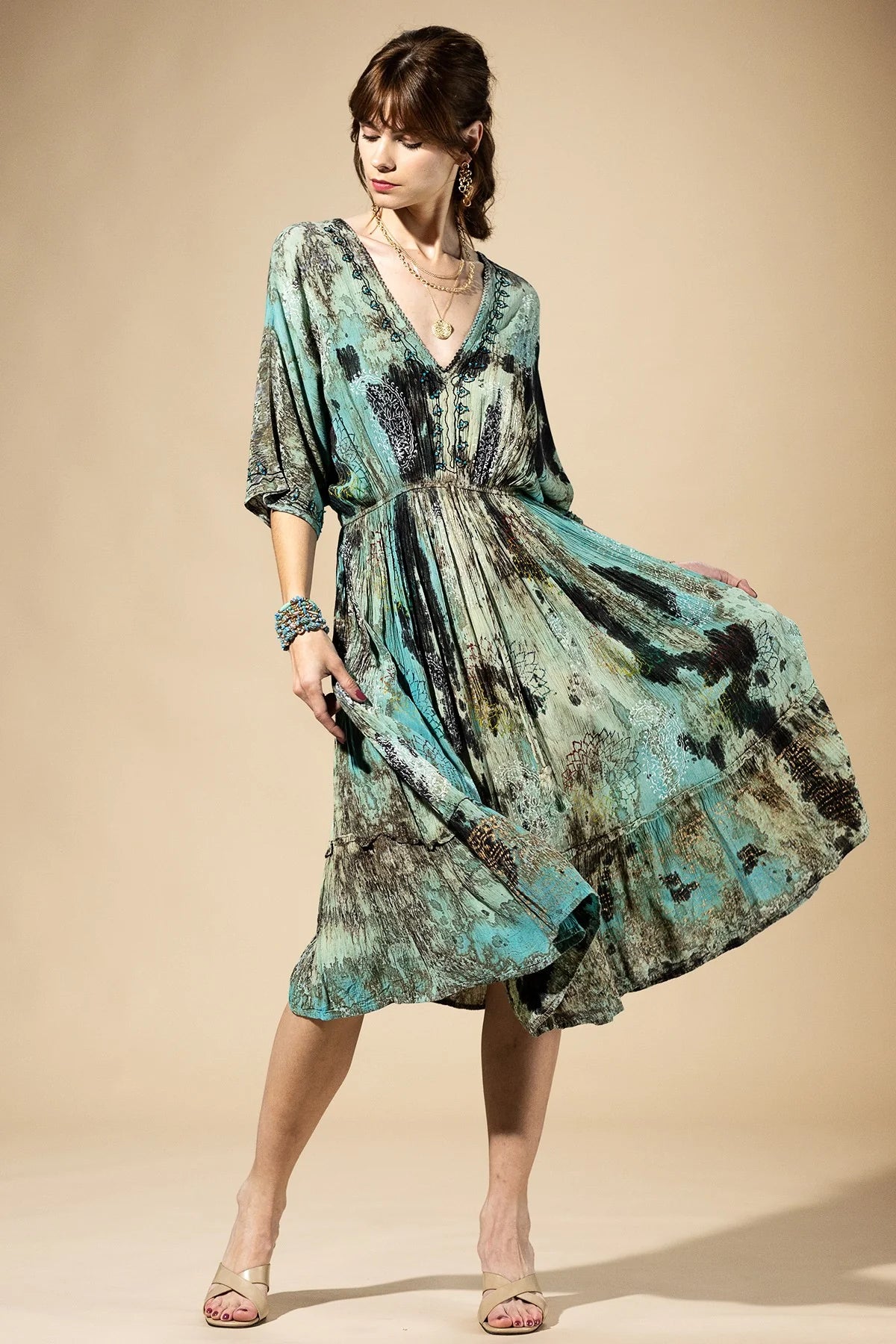 Woman wearing a patterned dress against a beige background