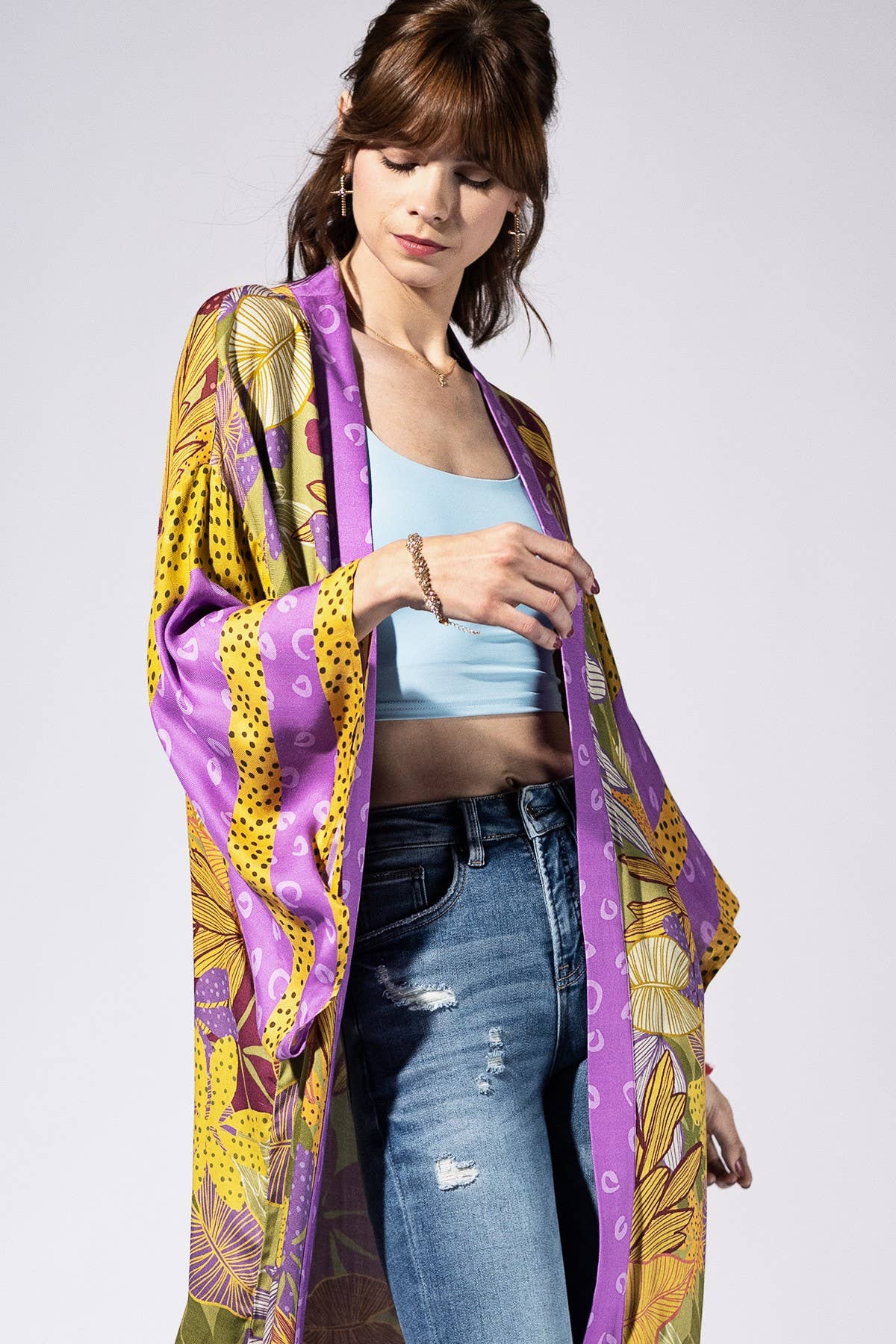 Woman wearing a colorful kimono-style garment with a white background