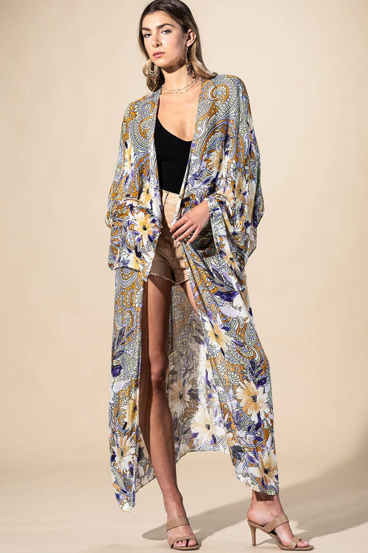 Woman wearing a long, patterned kimono-style garment against a beige background