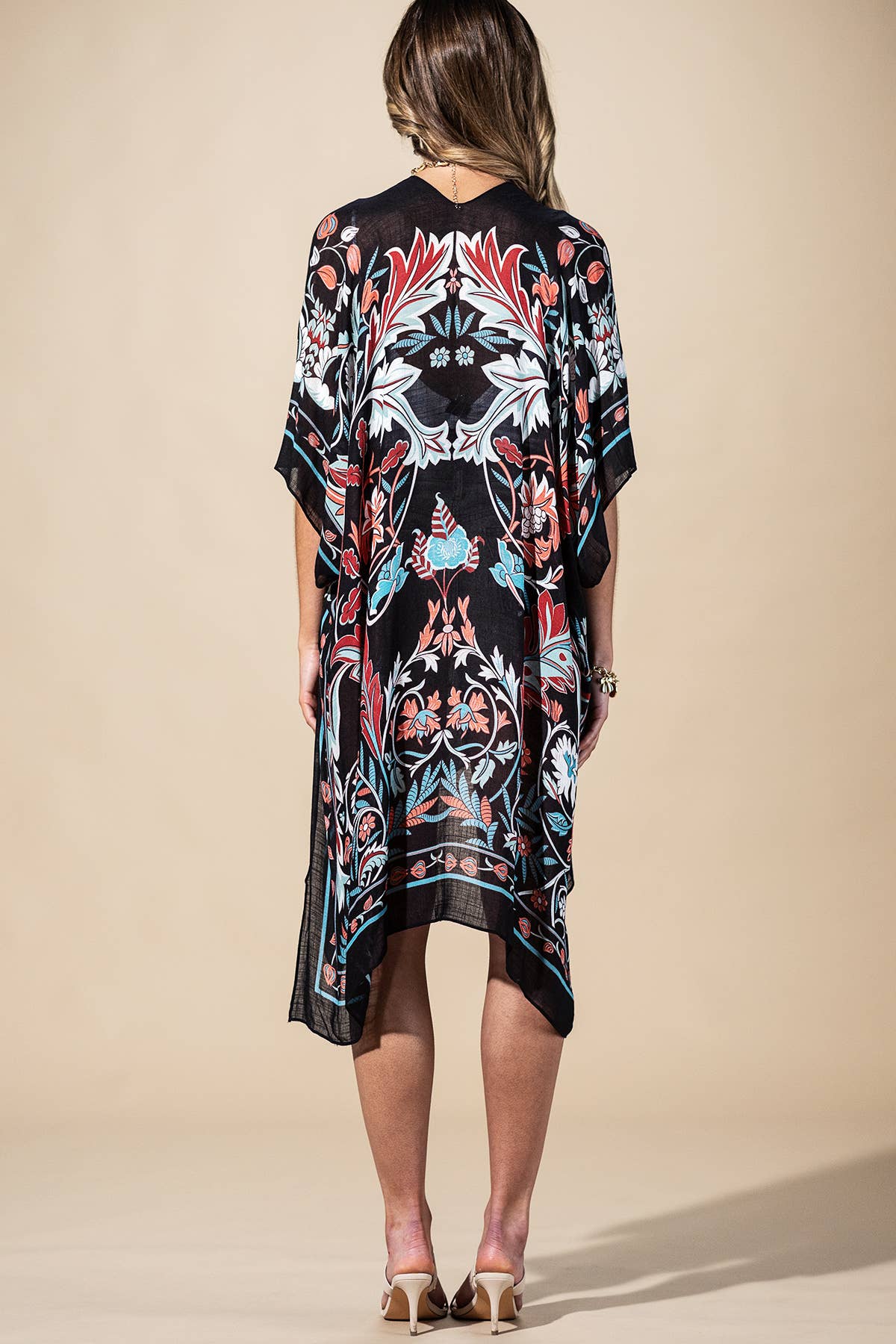 Woman wearing a patterned dress against a beige background