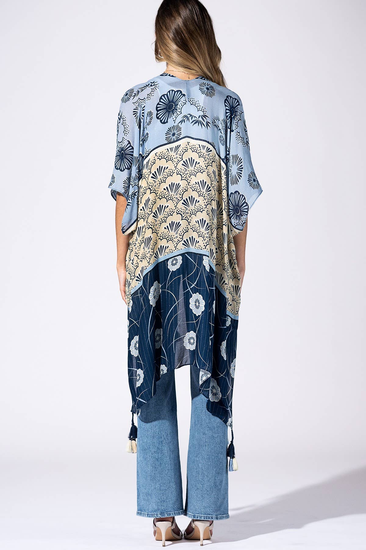 Woman wearing a floral kimono-style garment on a white background