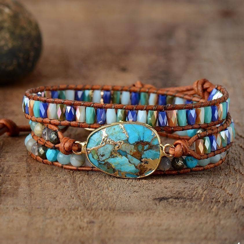 Multistrand beaded bracelet with turquoise stone on a wooden surface.