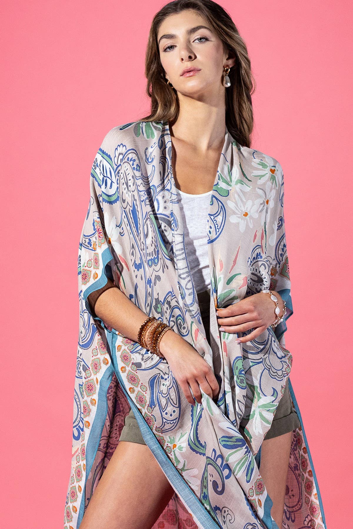 Woman wearing a colorful patterned kimono against a pink background