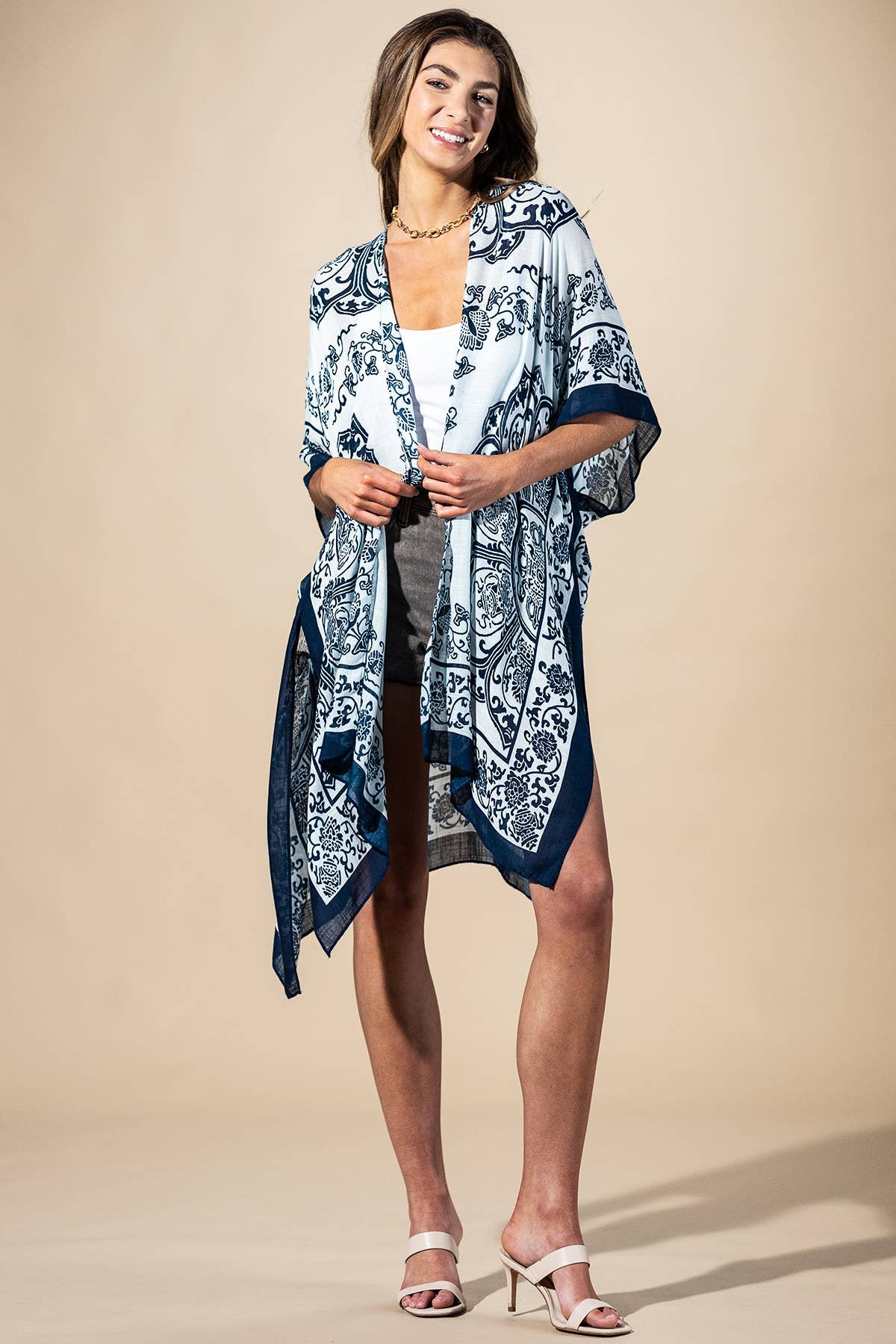 Woman wearing a blue and white patterned kimono over a dress on a beige background