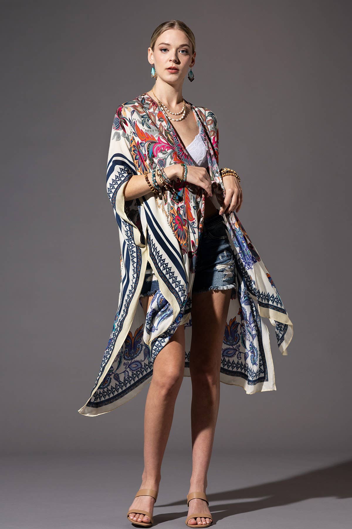 Woman wearing a patterned kimono-style garment against a gray background