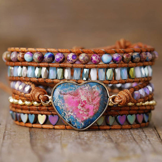 Multistrand beaded bracelet with a heart-shaped gemstone on a wooden surface, branded 'Free Spirit Shop'.