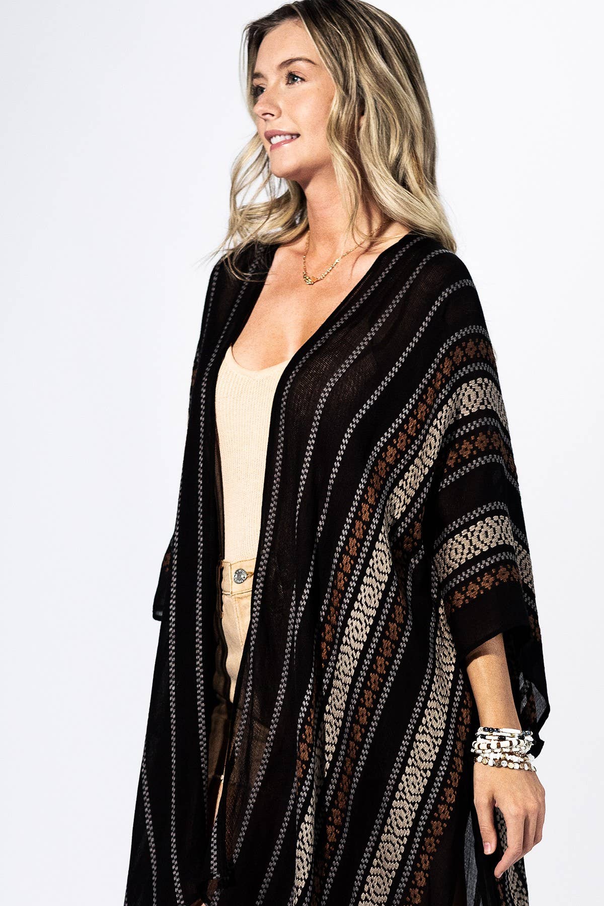 Woman wearing a black patterned cardigan on a white background