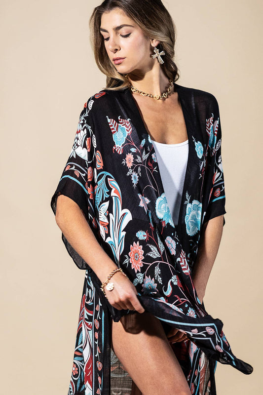 Woman wearing a black floral kimono over a white top on a beige background