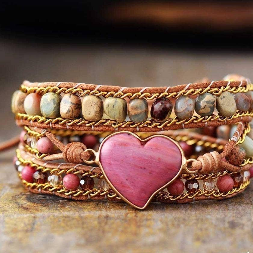 Multistrand bracelet with heart-shaped pink stone on a wooden surface, 