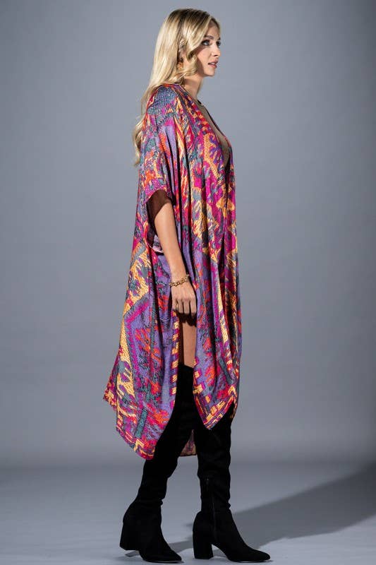 Woman wearing a colorful patterned kimono over a black outfit on a gray background