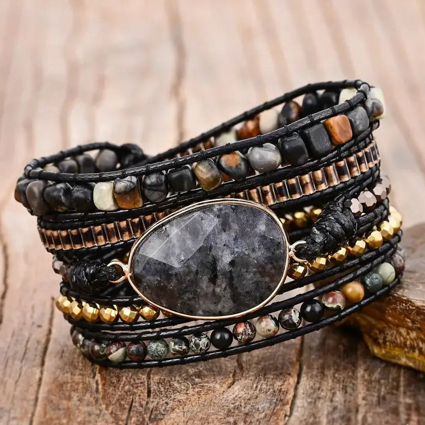 Multistrand beaded bracelet with a central stone on a wooden surface,