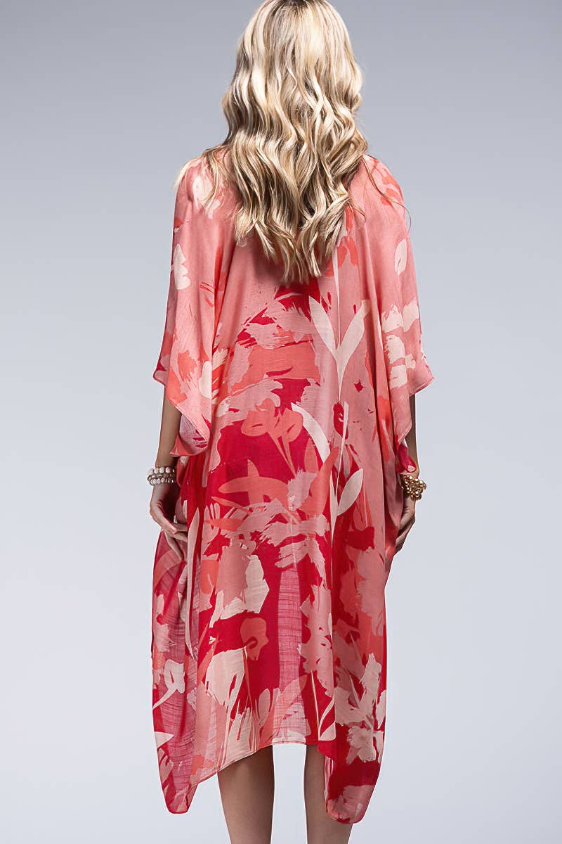 Woman wearing a red floral kimono-style garment on a gray background